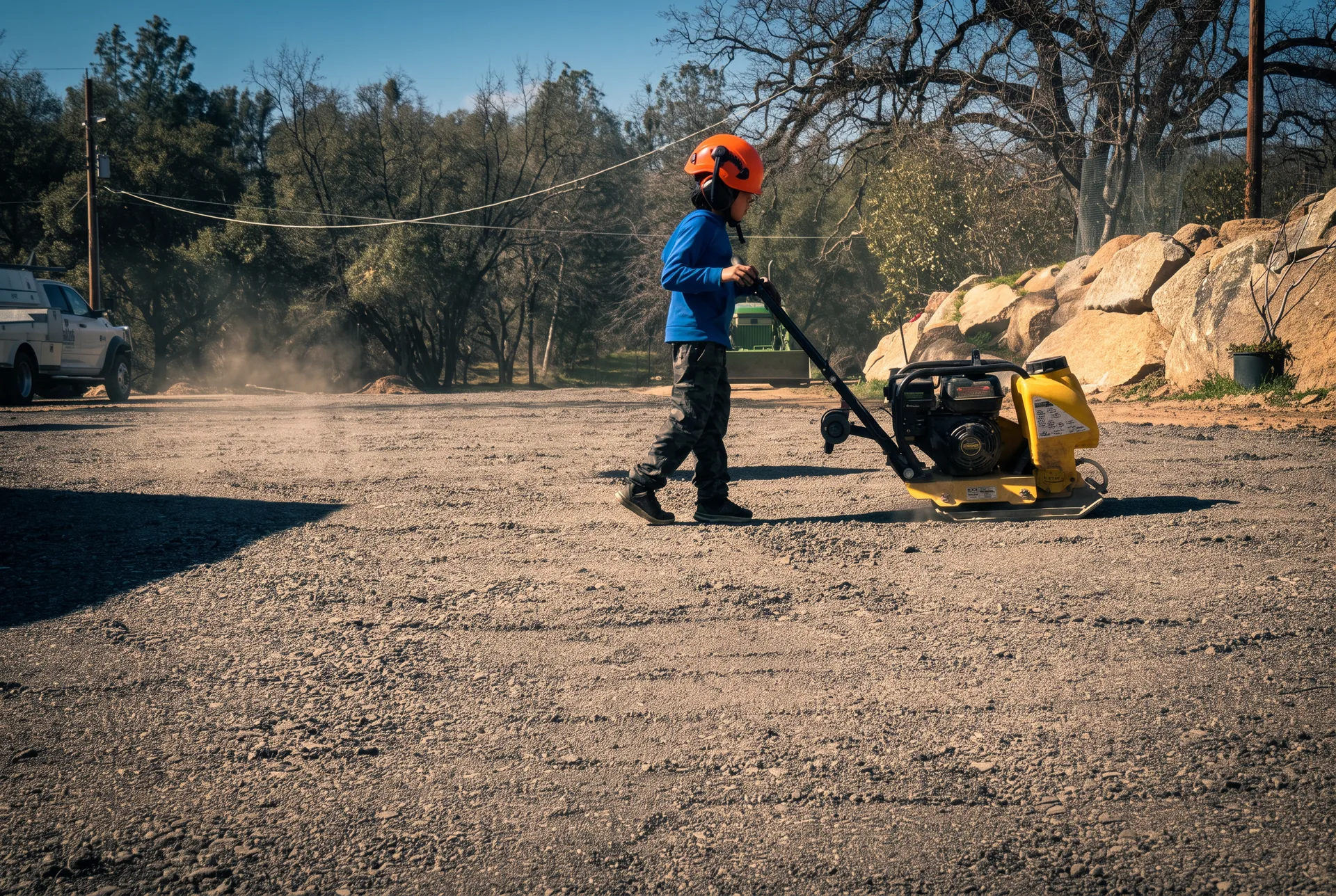 Crew compacting a gravel driveway on a Sierra foothill property